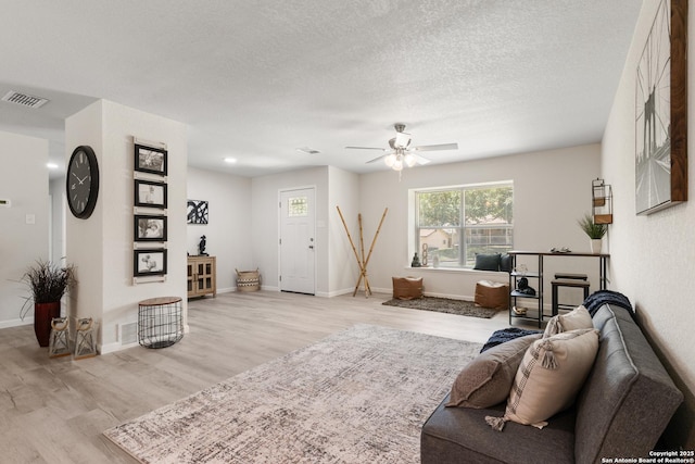 3115 Bluefield, San Antonio, TX 78230 - living room featuring light wood finished floors, a ceiling fan, baseboards, and a textured ceiling