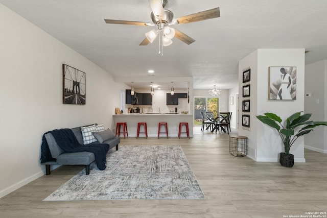 3115 Bluefield, San Antonio, TX 78230 - living room featuring light wood finished floors, a chandelier, baseboards, and a ceiling fan