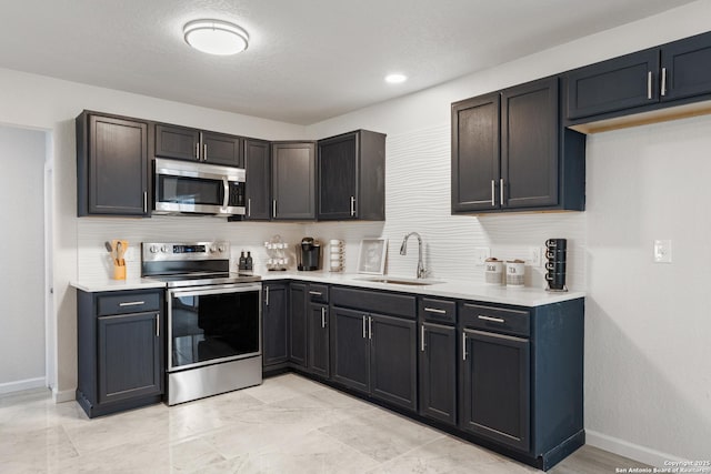 3115 Bluefield, San Antonio, TX 78230 - kitchen with appliances with stainless steel finishes, a sink, tasteful backsplash, light countertops, and baseboards