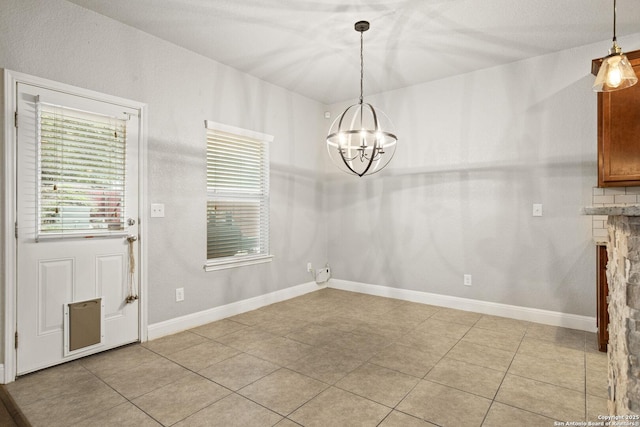 10307 Royal, San Antonio, TX 78245 - unfurnished dining area featuring light tile patterned floors, a chandelier, baseboards, and a stone fireplace