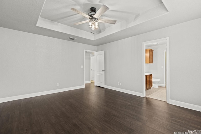 10307 Royal, San Antonio, TX 78245 - unfurnished bedroom featuring a raised ceiling, dark wood-style floors, and baseboards