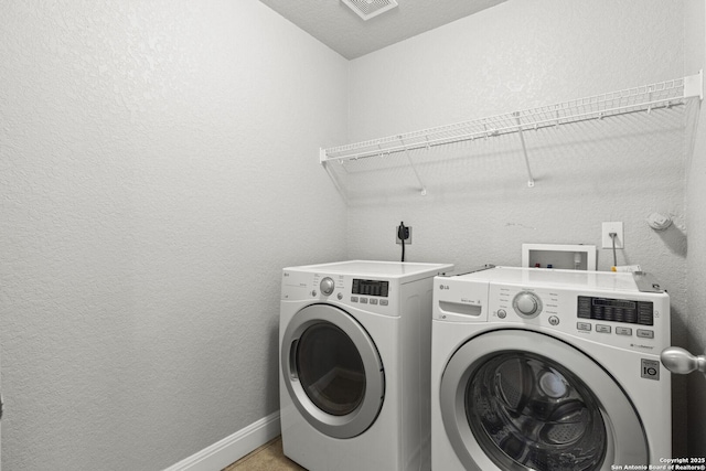 10307 Royal, San Antonio, TX 78245 - laundry area with washer and dryer, a textured wall, and baseboards