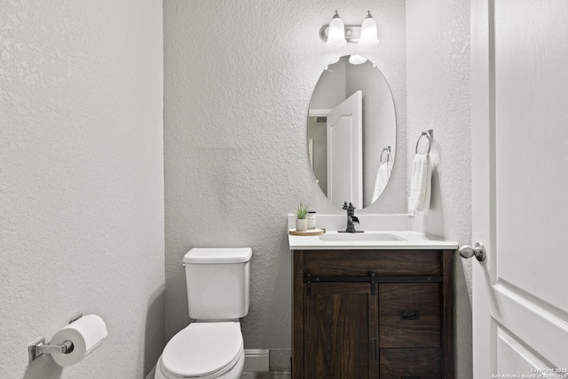 10307 Royal, San Antonio, TX 78245 - bathroom with toilet, vanity, and a textured wall