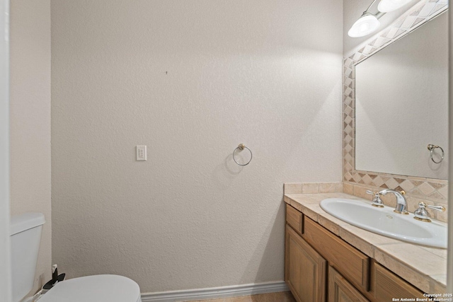 2001 Crown Rdg, Kerrville, TX 78028 - bathroom with toilet, vanity, decorative backsplash, and baseboards