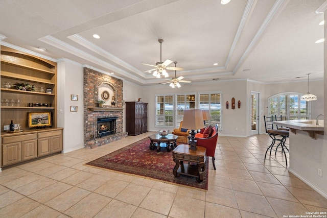 2001 Crown Rdg, Kerrville, TX 78028 - living area featuring a tray ceiling, a fireplace, light tile patterned floors, built in shelves, and baseboards