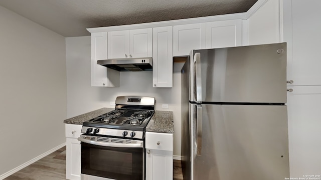 13778 Bradford Park, San Antonio, TX 78253 - kitchen featuring under cabinet range hood, stainless steel appliances, white cabinets, dark stone counters, and wood finished floors