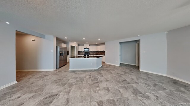 7918 Hanging, San Antonio, TX 78253 - kitchen featuring stainless steel refrigerator with ice dispenser, open floor plan, black microwave, dark countertops, and white cabinets
