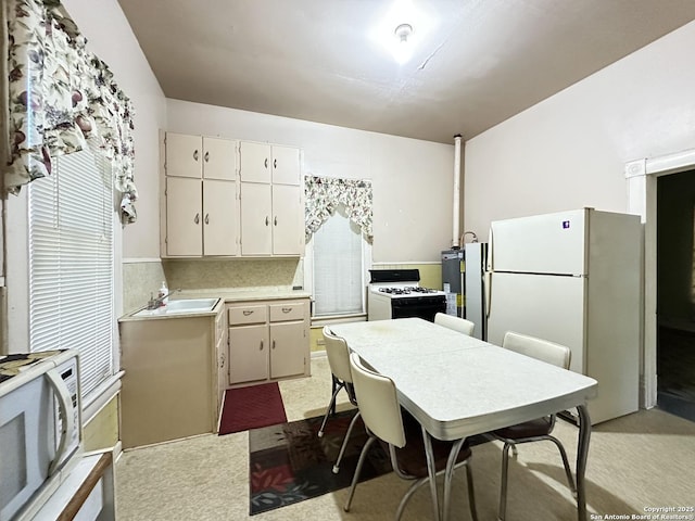 2222 Osburn, San Antonio, TX 78208 - kitchen with white appliances, light countertops, a sink, and white cabinets