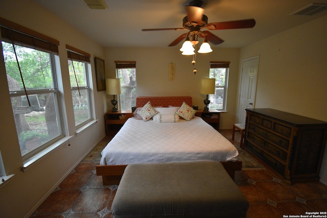 tiled bedroom featuring baseboards and a ceiling fan