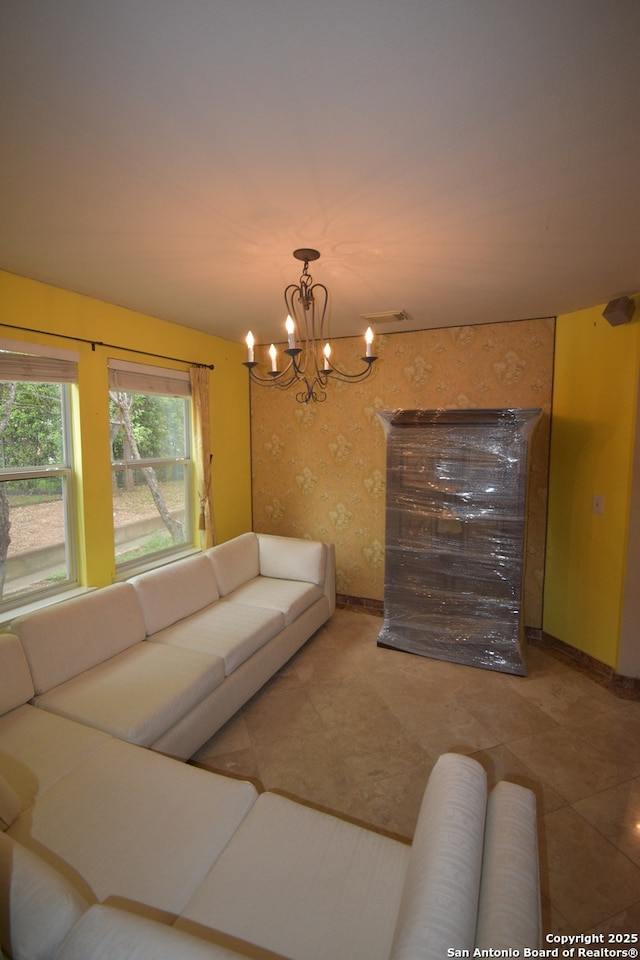 living room featuring a chandelier, tile patterned floors, wallpapered walls, and baseboards