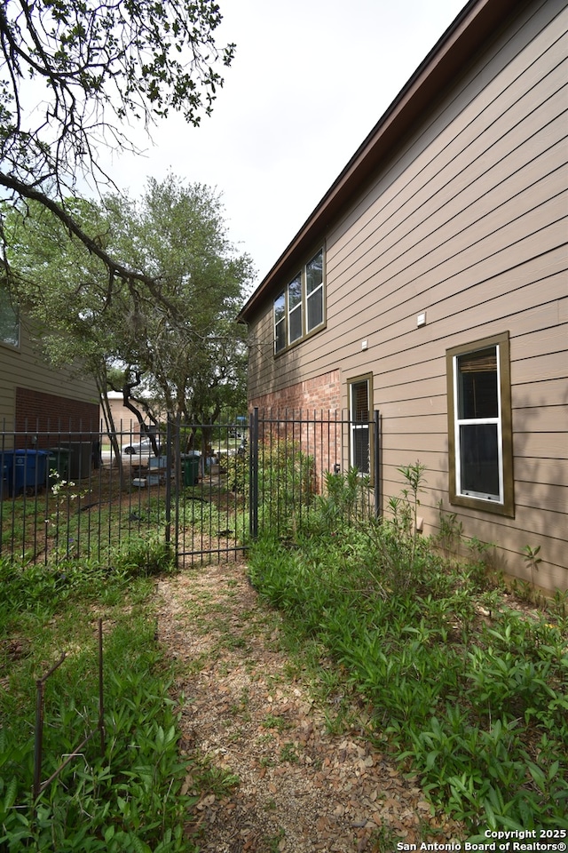 view of side of home featuring fence