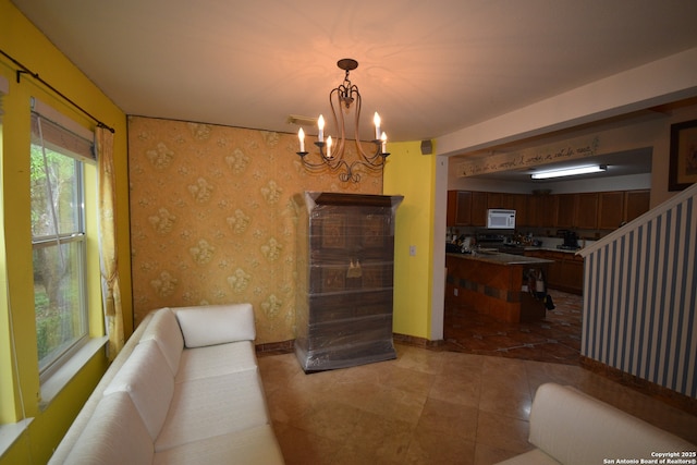 living room featuring a chandelier, wallpapered walls, tile patterned flooring, and baseboards