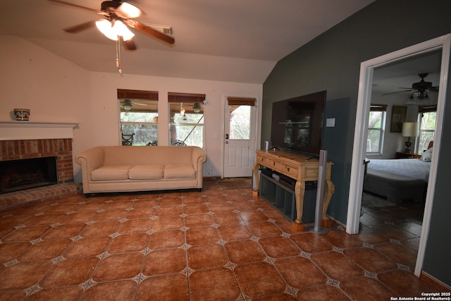 living room featuring ceiling fan, vaulted ceiling, healthy amount of natural light, and a fireplace