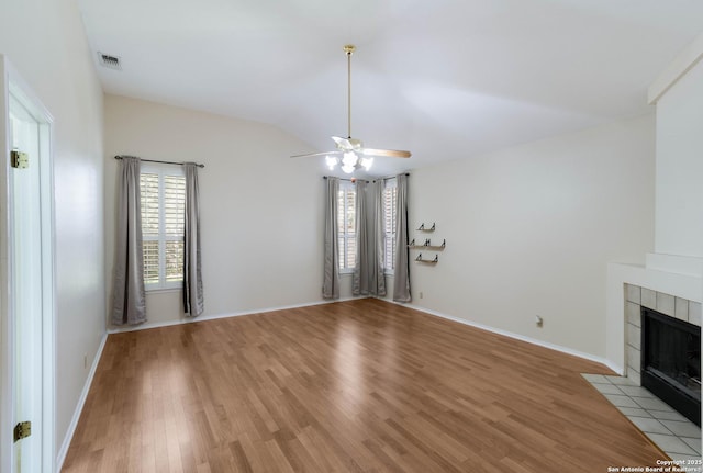 5919 Cedar Path, San Antonio, TX 78249 - unfurnished living room featuring plenty of natural light, vaulted ceiling, light wood finished floors, a ceiling fan, and a tiled fireplace