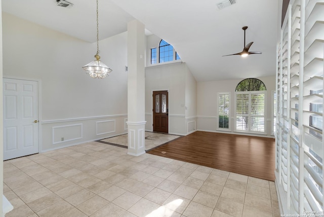 5919 Cedar Path, San Antonio, TX 78249 - foyer entrance with high vaulted ceiling, light tile patterned floors, ornate columns, a ceiling fan, and a chandelier