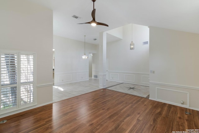 5919 Cedar Path, San Antonio, TX 78249 - unfurnished room featuring wood finished floors, a decorative wall, a ceiling fan, wainscoting, and lofted ceiling