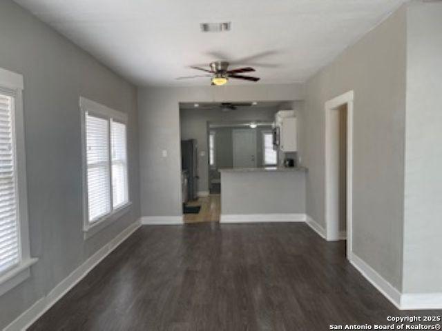 1239 Kayton, San Antonio, TX 78210 - unfurnished living room featuring dark wood-type flooring, baseboards, and ceiling fan