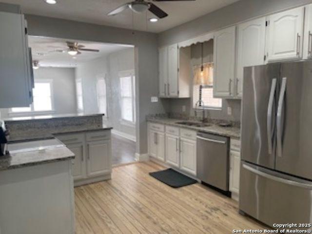1239 Kayton, San Antonio, TX 78210 - kitchen featuring appliances with stainless steel finishes, a ceiling fan, light wood finished floors, white cabinetry, and recessed lighting