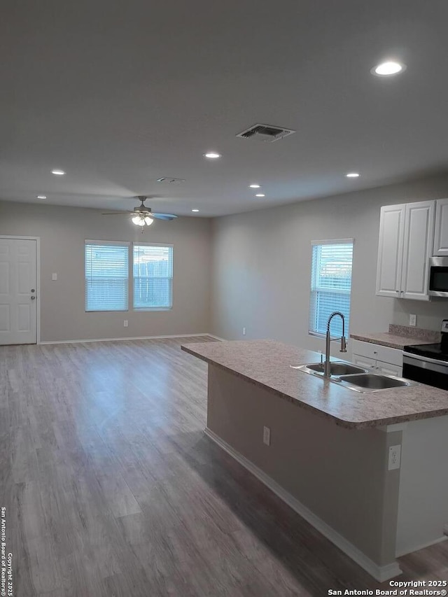 530 Pleasanton, San Antonio, TX 78221 - kitchen featuring appliances with stainless steel finishes, white cabinets, light countertops, light wood-style flooring, and recessed lighting