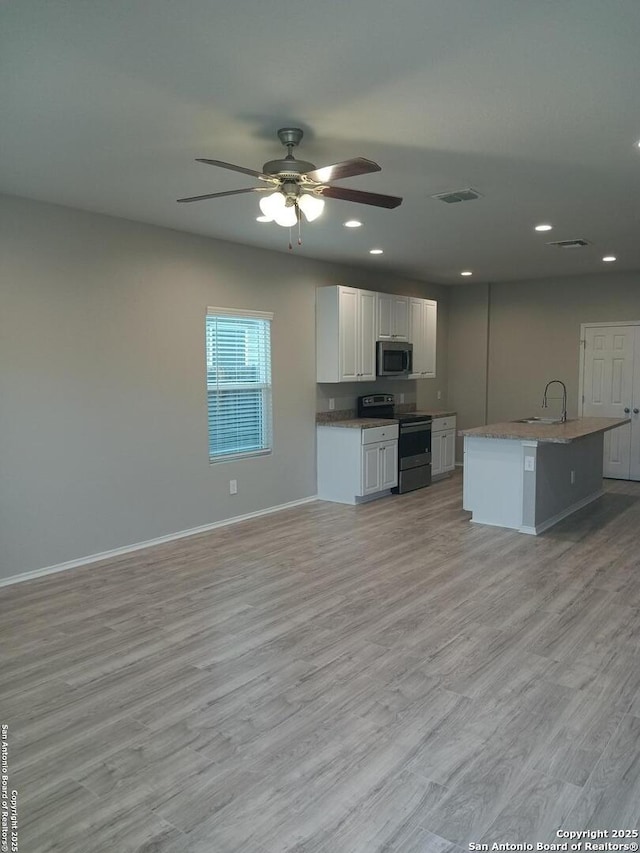 530 Pleasanton, San Antonio, TX 78221 - kitchen with appliances with stainless steel finishes, baseboards, white cabinetry, ceiling fan, and light wood-type flooring