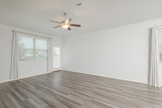 unfurnished room featuring ceiling fan, wood finished floors, and baseboards