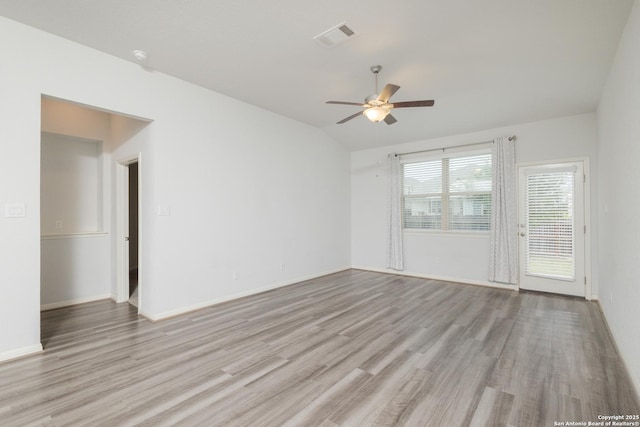 spare room featuring a ceiling fan, wood finished floors, baseboards, and vaulted ceiling