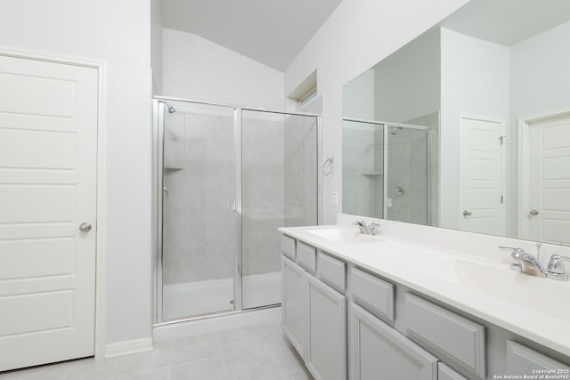 full bath with a stall shower, double vanity, lofted ceiling, and tile patterned floors