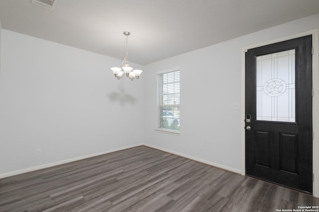 entryway featuring dark wood-style flooring, a chandelier, and baseboards