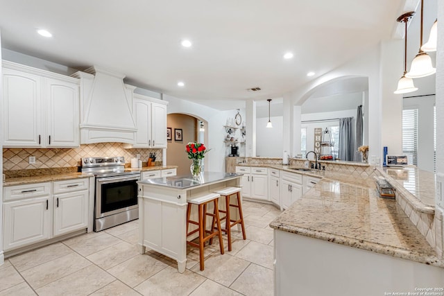 515 County Road 3822, San Antonio, TX 78253 - kitchen featuring stainless steel electric range oven, premium range hood, a sink, arched walkways, and backsplash