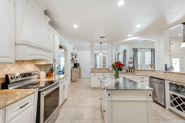 515 County Road 3822, San Antonio, TX 78253 - kitchen featuring appliances with stainless steel finishes, decorative backsplash, arched walkways, recessed lighting, and white cabinets