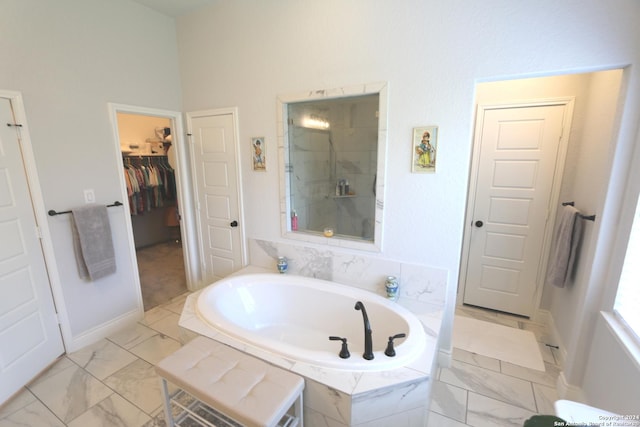 2965 Grove Way, Seguin, TX 78155 - bathroom featuring tiled shower, a garden tub, a spacious closet, and baseboards
