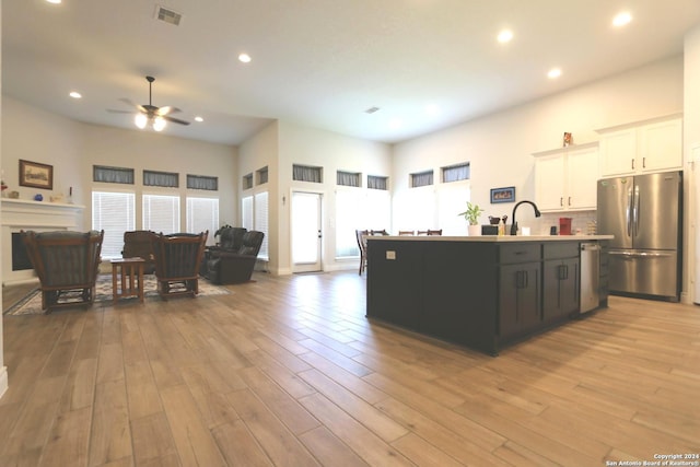 2965 Grove Way, Seguin, TX 78155 - kitchen featuring appliances with stainless steel finishes, open floor plan, a ceiling fan, white cabinets, and an island with sink