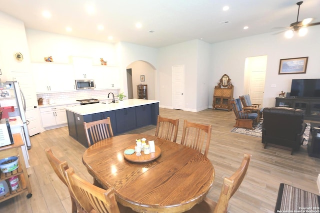 2965 Grove Way, Seguin, TX 78155 - dining space featuring arched walkways, light wood finished floors, a ceiling fan, and recessed lighting
