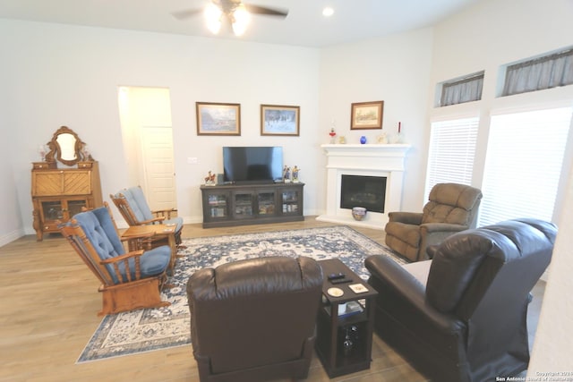 2965 Grove Way, Seguin, TX 78155 - living area featuring wood finished floors, a ceiling fan, a fireplace with raised hearth, baseboards, and recessed lighting