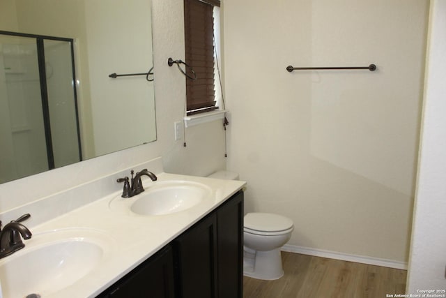 482 Walnut, Selma, TX 78154 - bathroom featuring wood finished floors, a shower stall, toilet, double vanity, and baseboards