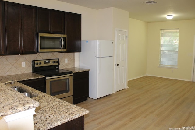 482 Walnut, Selma, TX 78154 - kitchen with stainless steel appliances, light wood finished floors, backsplash, and dark brown cabinetry
