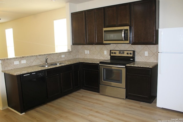 482 Walnut, Selma, TX 78154 - kitchen featuring appliances with stainless steel finishes, a sink, backsplash, and light wood-style floors