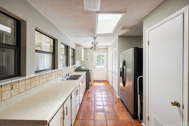 7214 N Vandiver, San Antonio, TX 78209 - kitchen with stainless steel fridge with ice dispenser, washer / dryer, a sink, tasteful backsplash, and a textured ceiling
