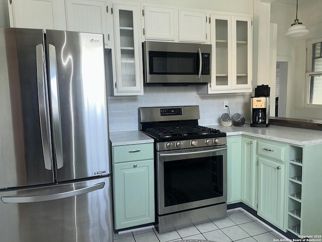 539 Wickes, San Antonio, TX 78210 - kitchen featuring stainless steel appliances, light countertops, light tile patterned flooring, tasteful backsplash, and glass insert cabinets