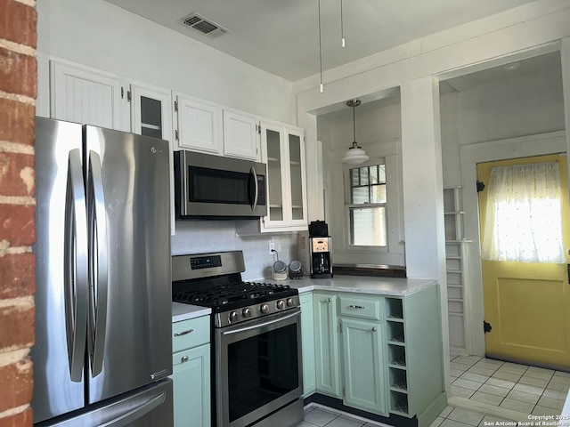 539 Wickes, San Antonio, TX 78210 - kitchen featuring appliances with stainless steel finishes, light countertops, light tile patterned flooring, and white cabinetry