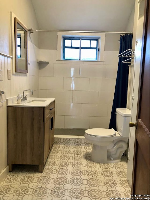 539 Wickes, San Antonio, TX 78210 - bathroom with toilet, tile walls, vanity, a shower with shower curtain, and tile patterned flooring
