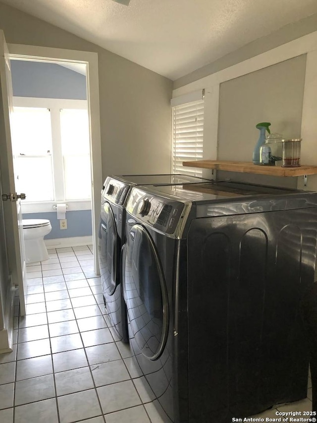 539 Wickes, San Antonio, TX 78210 - laundry room featuring independent washer and dryer, light tile patterned floors, baseboards, and a textured ceiling