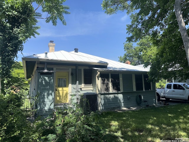 539 Wickes, San Antonio, TX 78210 - view of front of property with a chimney, a front yard, metal roof, and a porch