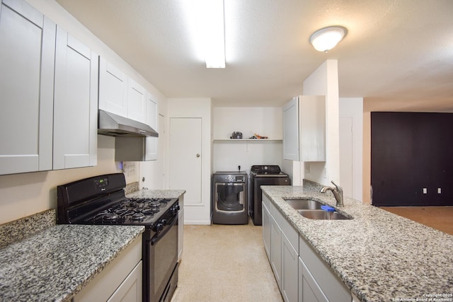 723 Clark Ave, San Antonio, TX 78210 - kitchen with under cabinet range hood, gas stove, a sink, washer and dryer, and light stone counters