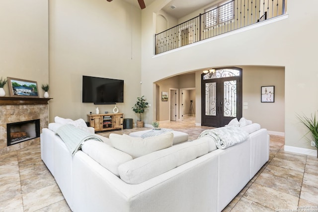 927 Scenic Stroll, San Antonio, TX 78260 - living area featuring arched walkways, a towering ceiling, french doors, baseboards, and a tile fireplace