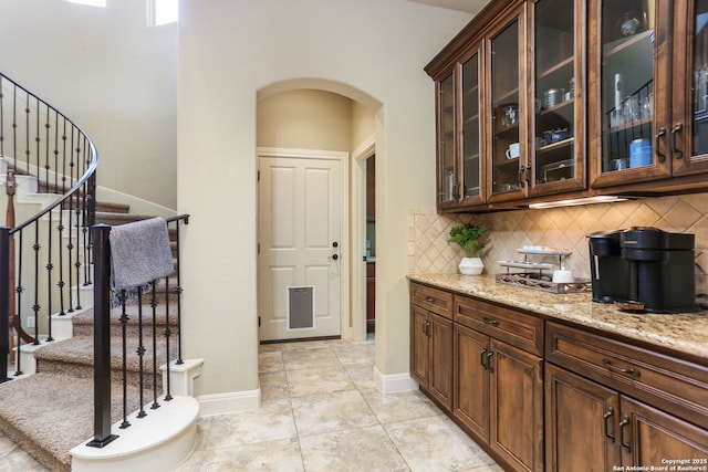 927 Scenic Stroll, San Antonio, TX 78260 - bar area featuring arched walkways, tasteful backsplash, stairs, baseboards, and light tile patterned floors
