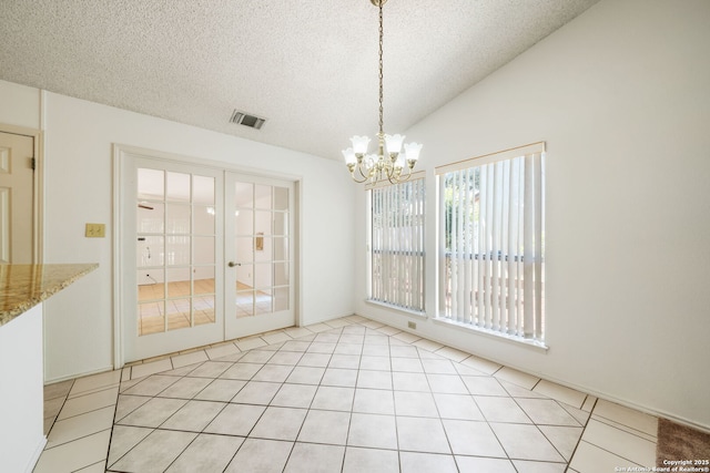 12138 W Lemon Blossom, San Antonio, TX 78247 - unfurnished dining area with french doors, a textured ceiling, a chandelier, light tile patterned flooring, and lofted ceiling
