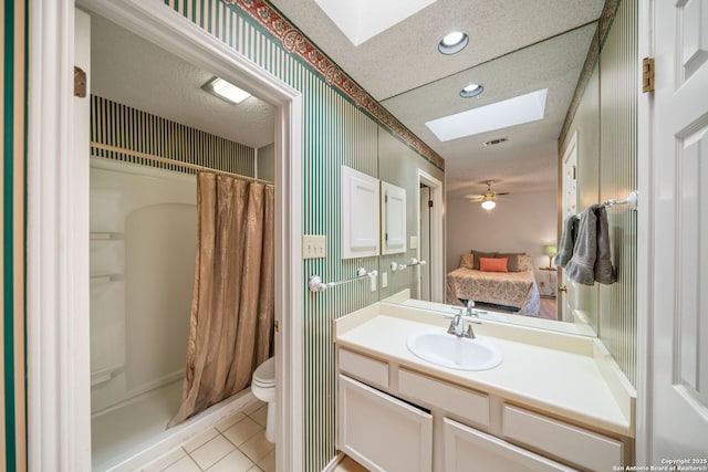 12138 W Lemon Blossom, San Antonio, TX 78247 - ensuite bathroom with a skylight, recessed lighting, tile patterned floors, vanity, and a textured ceiling