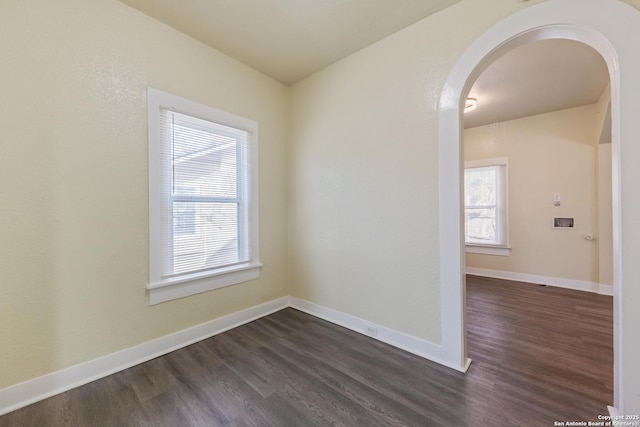 110 Muth, San Antonio, TX 78208 - spare room with arched walkways, dark wood finished floors, and baseboards