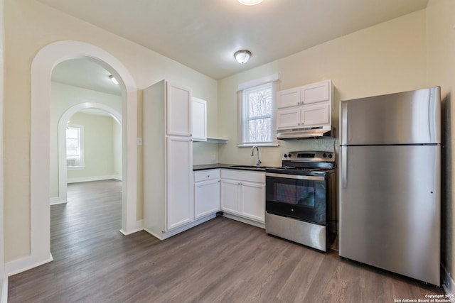 110 Muth, San Antonio, TX 78208 - kitchen with appliances with stainless steel finishes, under cabinet range hood, dark wood-style flooring, and a sink